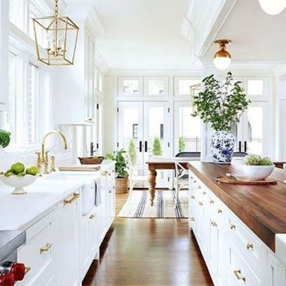 a white kitchen with gold furnishings